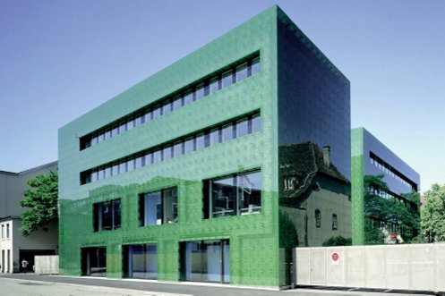 Aussenansicht auf die grüne Glasfassade der Spitalapotheke mit Blick von der Spitalstrasse